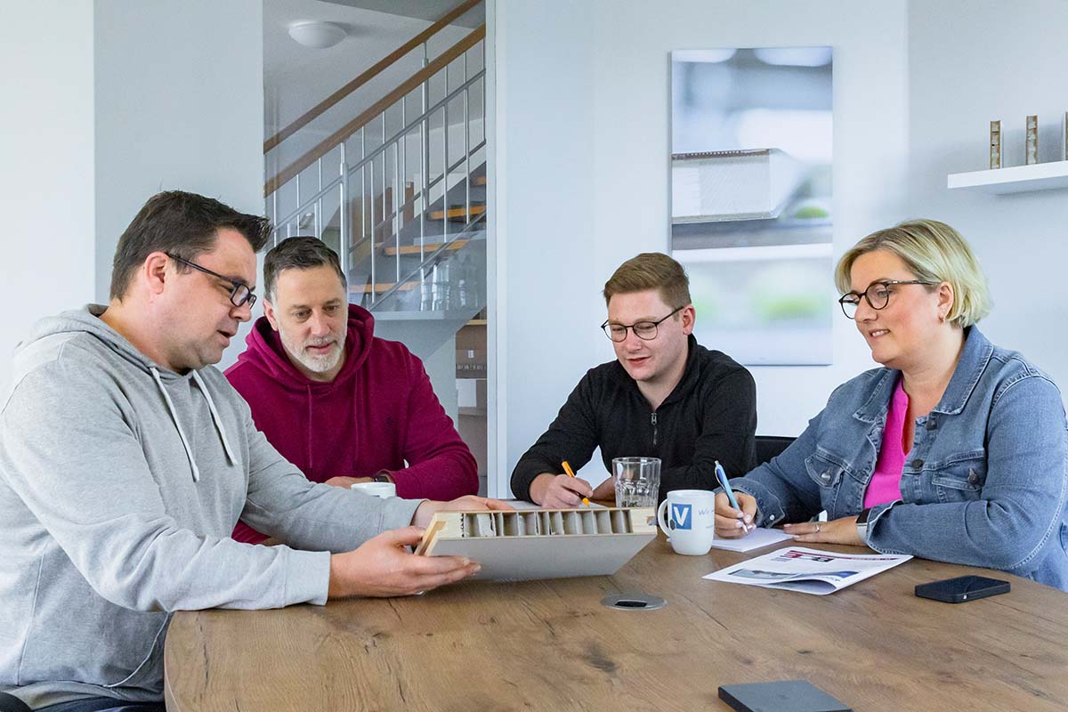 Vier Personen am Schreibtisch bei einer Projektbesprechung